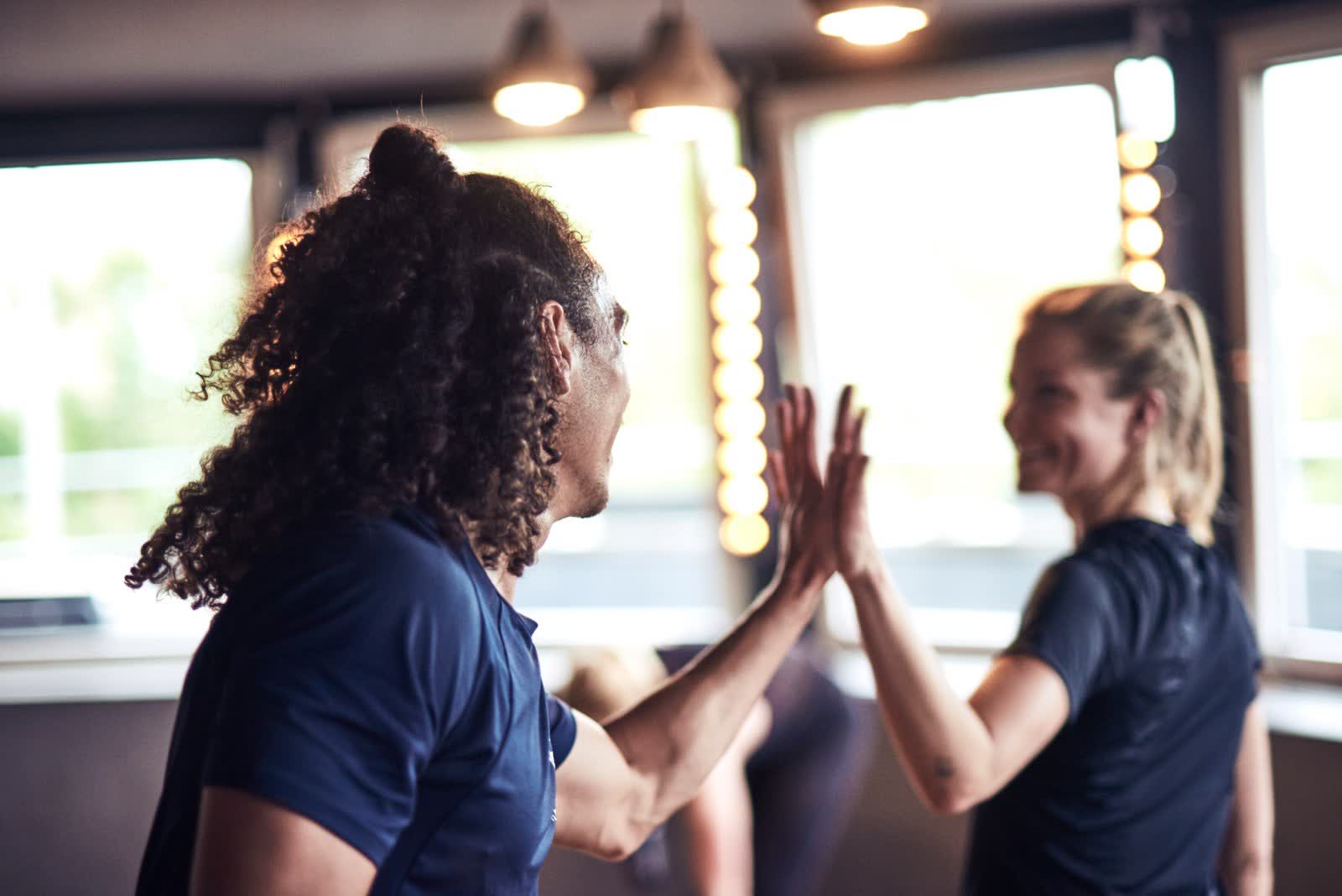 Florian high-fiving a smiling woman during a coaching session