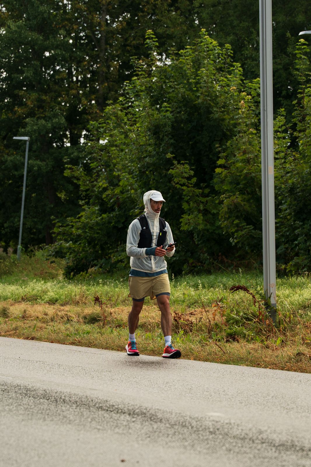 Florian walking along a country road in his running gear, between two stretches
